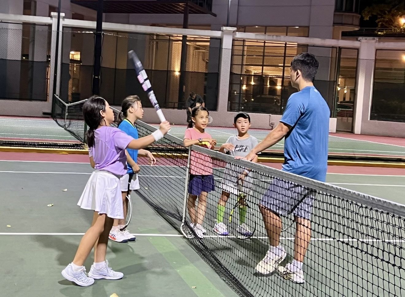 Coach Sherwin Foo taking a junior group session at the net