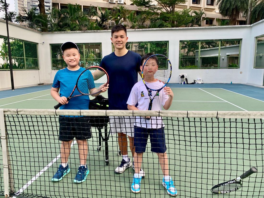 Coach Sherwin Foo with two junior players at the net after a session